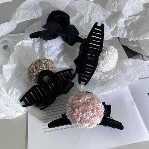Détail de la pince à cheveux à nœud en velours et des boules en peluche douces