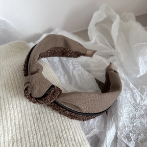 Detail showing the brown fabric twisted headband with textured tweed and soft knit edges