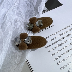 Détail de pinces à cheveux floquées marron avec des cristaux en forme de papillon