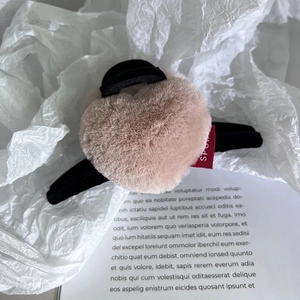Détail de la grande pince à cheveux en peluche rose en forme de cœur avec base noire