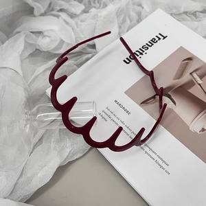Detail of dark red wavy headband with non-slip teeth on a white magazine background