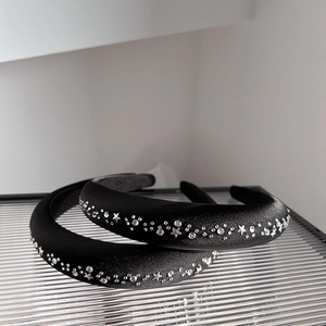 Vue détaillée de serre-têtes rembourrés en velours noir avec motifs d'étoiles en strass
