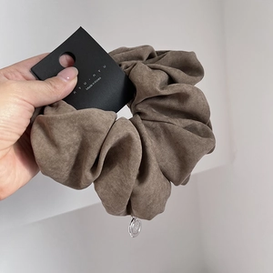 Elegant large brown fabric scrunchie with silver metal pendant for low ponytail hairstyles