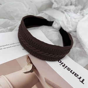 Détail du serre-tête en tricot marron foncé avec maille torsadée classique et doublure douce