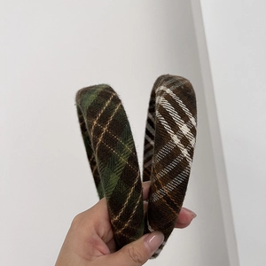 Detail of British style checkered padded headbands in green and brown wool fabric