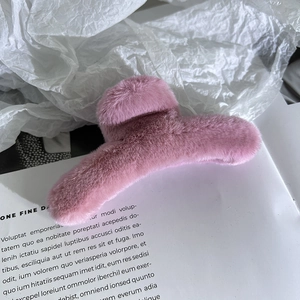 Dettaglio di una grande molletta per capelli in finta pelliccia color malva per l'inverno