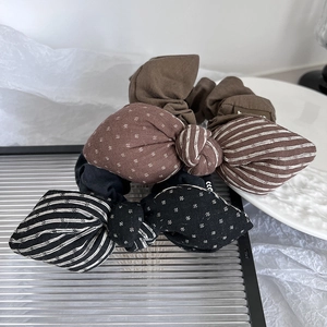 Detail of retro bow scrunchies with stripes and polka dots on a silver tray