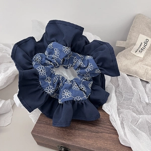 Navy blue denim floral scrunchie with white daisy embroidery and pleated ruffle details