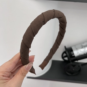 Brown fabric headband with pleated wrap design and delicate black micro bead accents