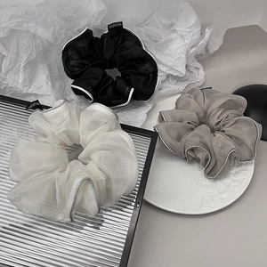 Detail of organza scrunchies in black white and gray with Fashion label tags