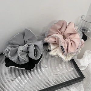 Eleganti elastici per capelli bicolore con motivo a lettere in grigio e rosa su vassoio