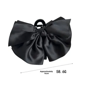 Détail d'une pince à cheveux avec nœud en satin noir de 16 cm pesant environ 58,6 g