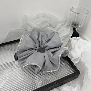 Dettaglio dell'elastico in tessuto grigio con pizzo a lettere e etichetta Fashion
