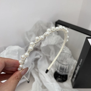 Detail van elegante dubbele rij parel haarband met zilveren kralen en beschermende tips