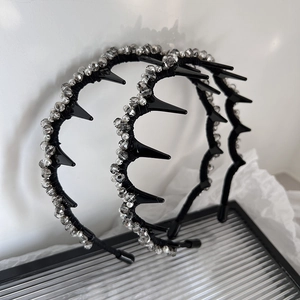 Luxury black spiked headband with crystal beads and pearls shown on a glass tray