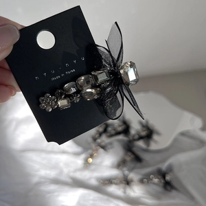 Close-up of a vintage black mesh butterfly hair clip with sparkling grey crystal stones