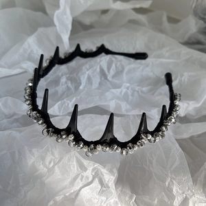 Detail of gothic black spiked headband with crystal beads and white pearls on top