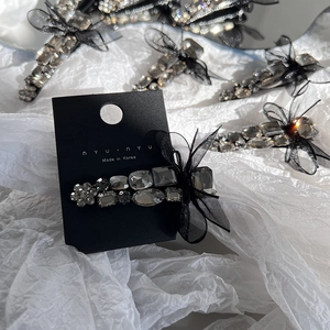 Elegant black bow hair clip with dark grey crystals and mesh veil on a white background