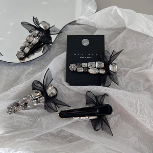 Detailed macro view of black mesh bow hair clips with multi-shaped shimmering rhinestones