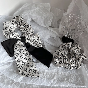 Detail of satin scrunchie with vintage black and white floral print and long bow decoration