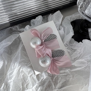 Detail of pink organza bow hairpins with large white pearls and rhinestone base