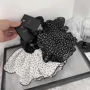 Ensemble de chouchous à pois et satin noir élégants sur un plateau en verre chic