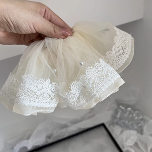 Elegant beige mesh hair scrunchie with floral lace edges and decorative white pearls
