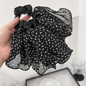 Détail du chouchou en mousseline noire à pois montrant la texture fluide du tissu