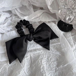 Detailansicht eines eleganten schwarzen Satin-Haargummis mit glänzender Textur