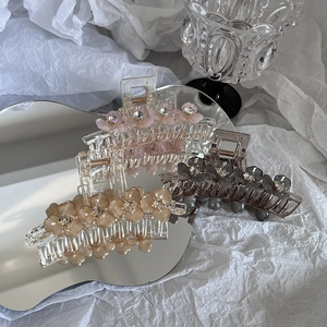 Détail de trois pinces à cheveux fleuries avec cristaux sur un miroir décoratif
