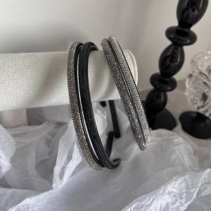 Detail view of thin headbands with sparkling rhinestones on elegant grey display stand