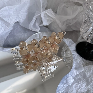 Détail macro d'une pince à cheveux florale ambrée avec strass sur base miroir