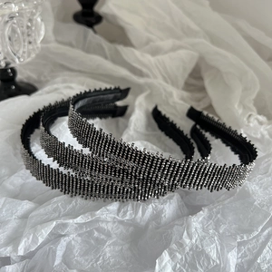 Luxurious black mesh headbands with sparkling rhinestones set on white silk background