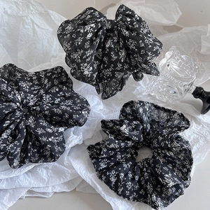 Floral hair accessories set with a large bow clip and two ruffled scrunchies on white tissue