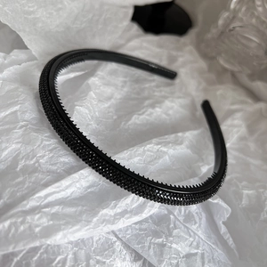 Detail showing non-slip teeth and black sparkling rhinestones on the slim headband