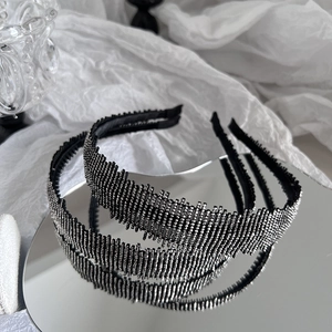 Elegant luxury black headband with sparkling silver rhinestones on a mirror surface