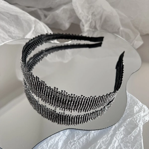 Detail of thin rhinestone headband with non-slip teeth reflected on a mirror surface