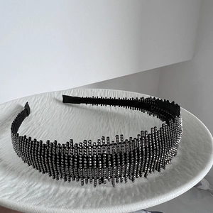 Detail of a luxury headband with full rhinestones and jagged tooth design on a stone tray