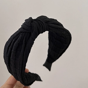 Classic black padded headband with top knot and quilted texture for volume