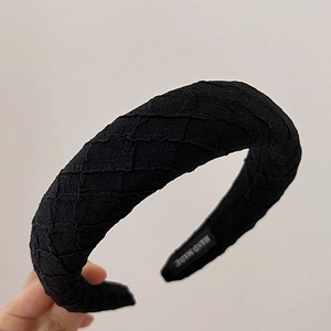 Classic black padded headband with textured sponge fabric and handmade woven label