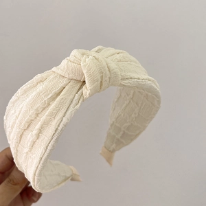 Elegant off-white padded headband with stylish top knot and textured fabric finish