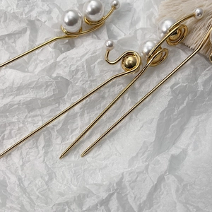 Épingle à cheveux dorée avec perles blanches pour une coiffure française minimaliste