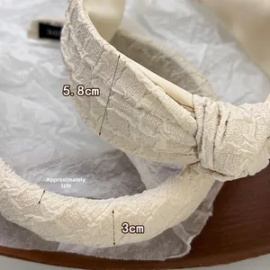 Close-up of cream pleated sponge headband with 5.8cm width and 3cm side thickness detail
