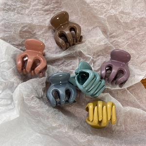 Detailed macro view of six colorful mini shark hair claws in assorted Morandi tones