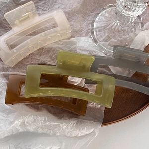 Dettaglio di grandi mollette per capelli quadrate in colori gelatina su carta