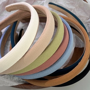 Pile de serre-têtes rembourrés en tissu coloré aux tons neutres sur fond blanc propre