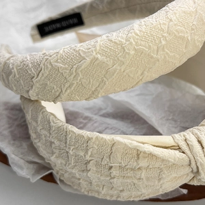 Detailed view of handmade textured jacquard headband fabric in creamy apricot color