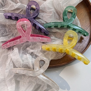 Vue rapprochée de pinces à cheveux translucides colorées en violet vert et rose