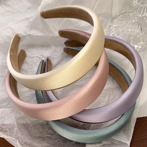 Close-up of thick sponge headbands with silk texture in cream, pink, purple, and blue colors