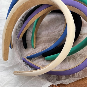 Detailed top view of padded sponge headbands in multiple retro colors on fabric